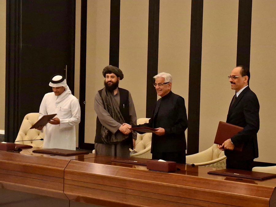 Afghan Taliban and Pakistani officials shake hands during a meeting in a formal setting, with Qatari and Turkish representatives standing beside them, signaling potential mediation efforts.